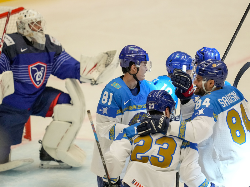 Kazašský hokejista Maxim Mukhametov sa raduje z gólu so spoluhráčmi 