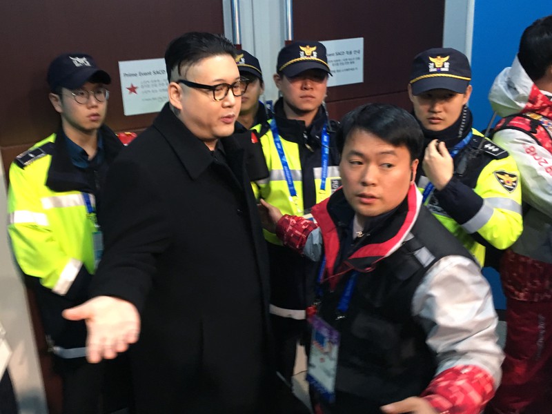 Howard z Austrálie, imitátor severokórejského lídra Kim Čong-una drží vlajku  zjednotenej výpravy uporiadateľskej Kórejskej republiky a KĽDR počas zápasu hokejového turnaja žien Kórea - Japonsko