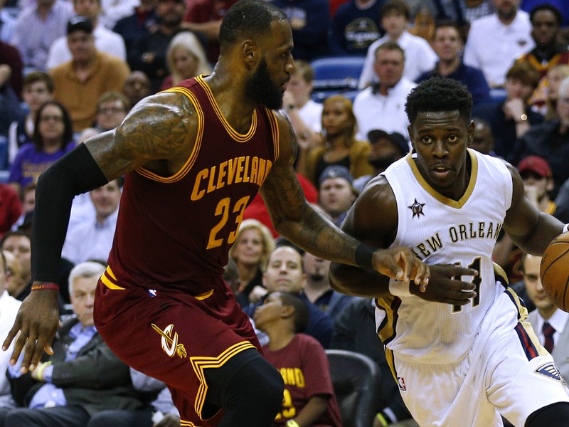 Jrue Holiday sa prediera cez brániaceho LeBrona Jamesa
