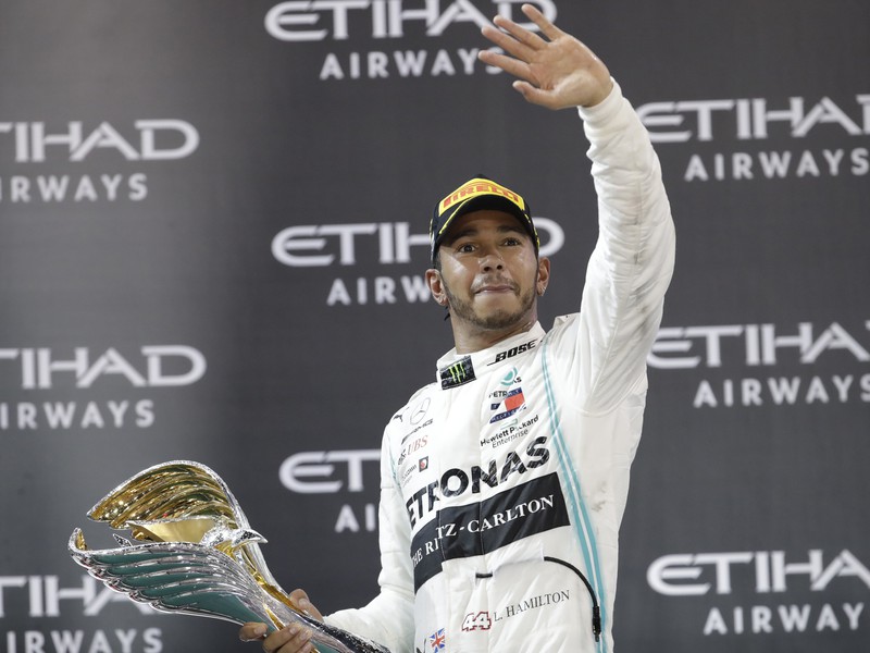 Lewis Hamilton oslavujúci s víťaznou trofejou