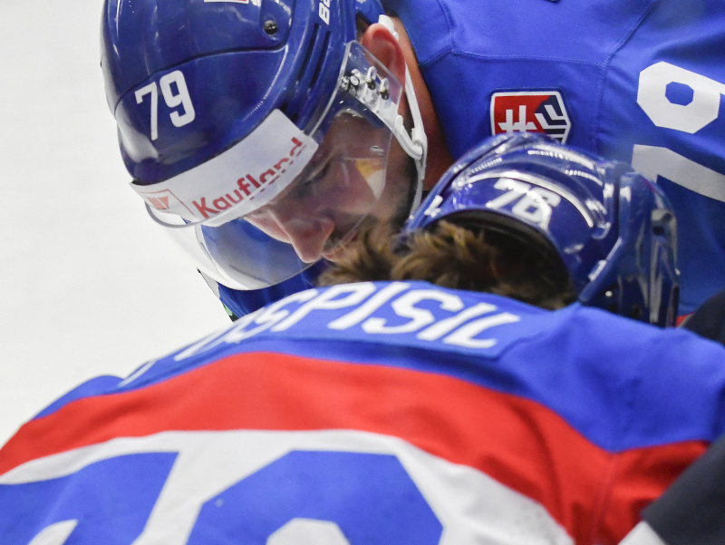 Na snímke zranený Martin Pospíšil (chrbtom), ktorému pomáha z ľadu spoluhráč Libor Hudáček (obaja Slovensko)