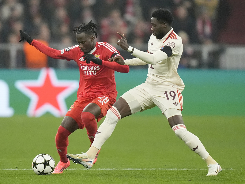 Hráč Bayernu Alphonso Davies (vpravo) bojuje o loptu s Issom Kaboreom z Benficy