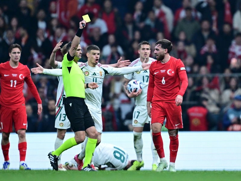 Turecký futbalista Orkun Kökcü, ktorému slovenský rozhodca Ivan Kružliak ukazuje žltú kartu 