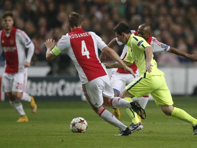 Lionel Messi a Niklas Moisander v súboji o loptu