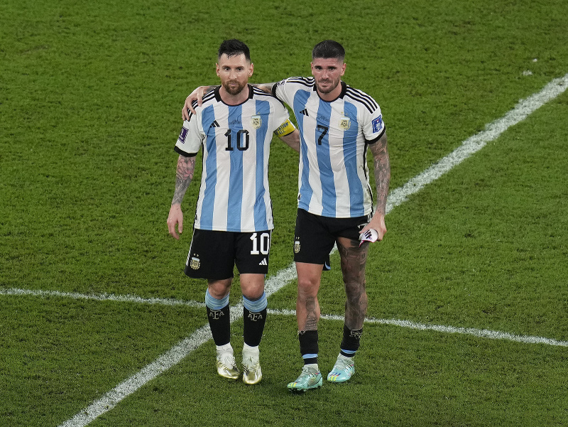 Lionel Messi pomáha Rodrigovi De Paulovi ísť dole z ihriska