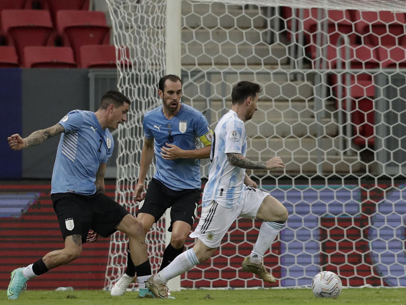 Lionel Messi uniká Diegovi Godínovi a Josému Gimenézovi