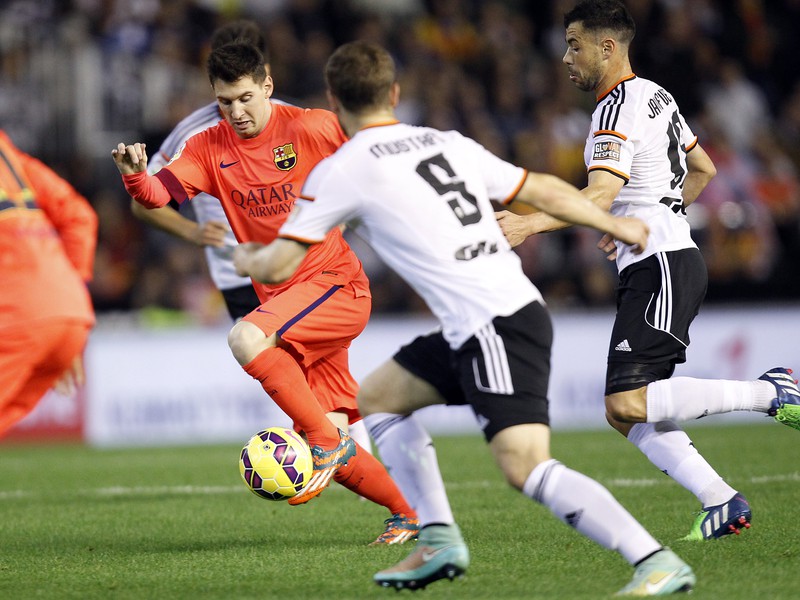 Lionel Messi preniká defenzívou Valencie
