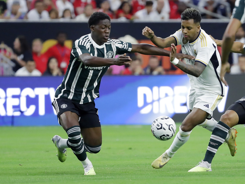 Futbalista Manchestru United Kobbie Mainoo (vľavo) a hráč Realu Madrid Rodrygo Silva (vpravo) bojujú o loptu