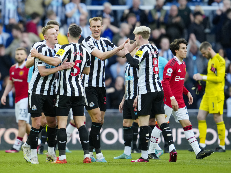 Víťazné oslavy futbalistov Newcastle, v pozadí sklamaní hráči Manchestru