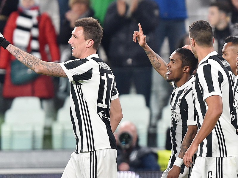 Douglas Costa so spoluhráčmi oslavuje vedúci gól Juventusu