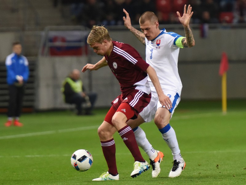 Kapitán Slovenska Martin Škrtel a hráč Lotyšska Artjoms Rudnevs