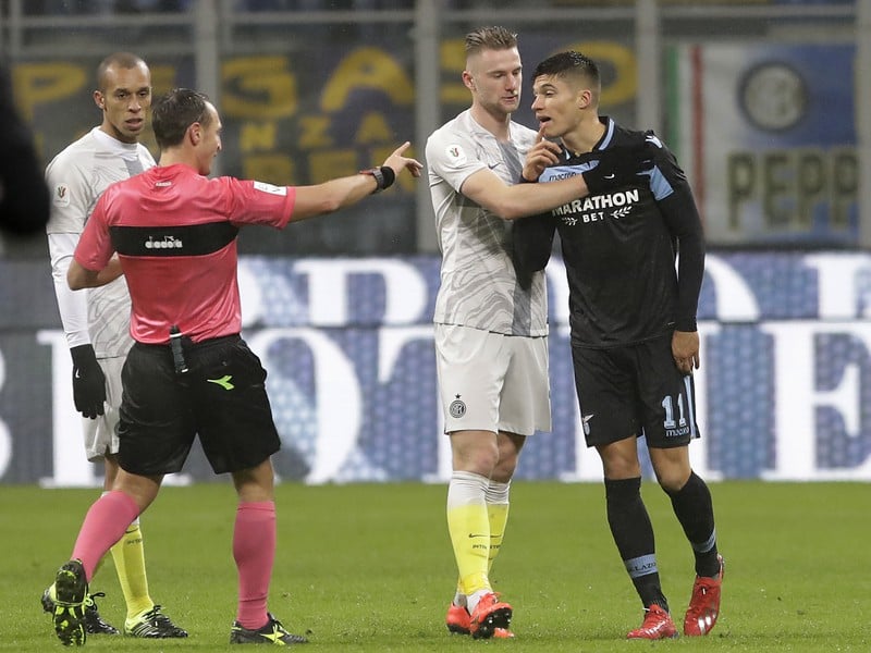 Rozhodca Rosario Abisso (vľavo) hovorí s hráčom Interu Miláno Milanom Škriniarom (druhý vpravo)
