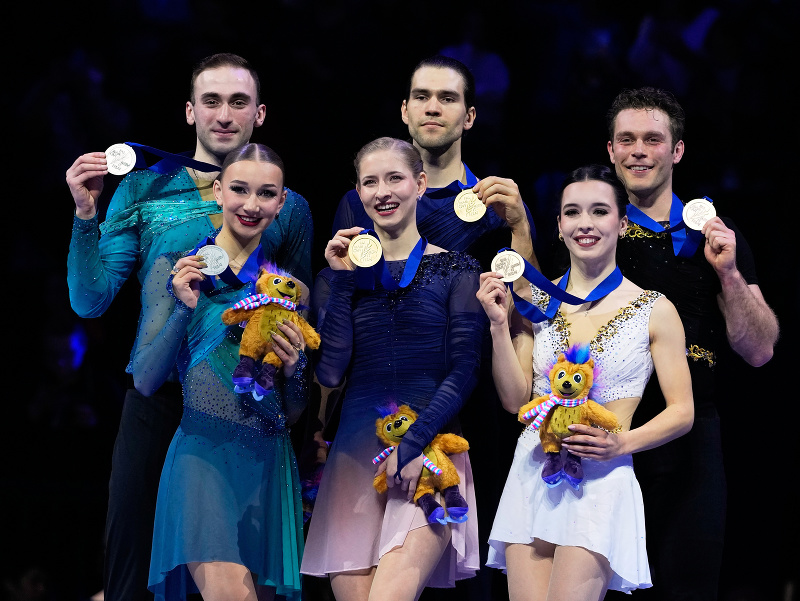 Minerva Fabienne Haseová a Nikita Volodin (uprostred) z Nemecka sa tešia zo zisku zlatej medaily v súťaži športových dvojíc na majstrovstvách sveta v krasokorčuľovaní v Prahe vo štvrtok 26. marca 2026. Striebro získali Anastasia Metelkinová, Luka Berulava