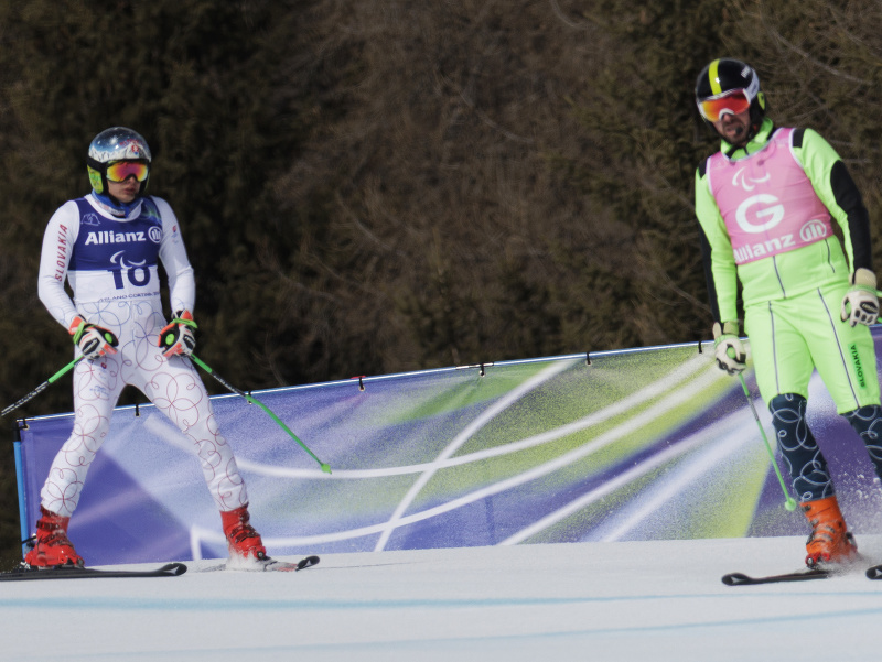 Na snímke vľavo slovenský paralpský lyžiar Miroslav Haraus s navádzačom Marošom Hudíkom schádza do cieľa pretekov super-G mužov na XIV. zimných paralympijských hrách 2026 v Cortine d'Ampezzo
