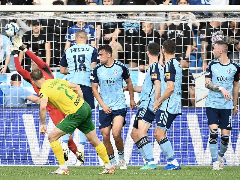 Na snímke v pozadí brankár Slovana Milan Borjan vyráža loptu po priamom kope hráča Žiliny Dominika Javorčeka