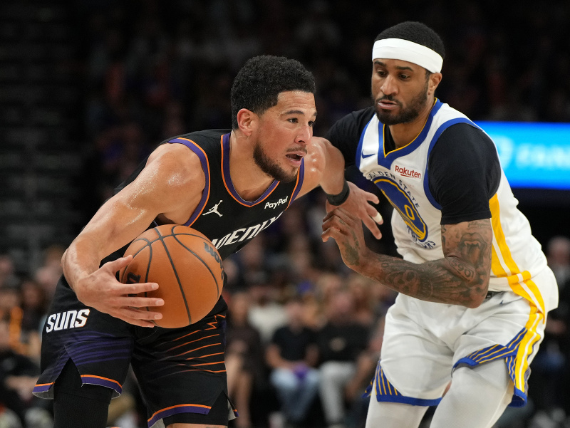Rozohrávač Phoenixu Suns Devin Booker útočí na rozohrávača Golden State Warriors Garyho Paytona II (0)