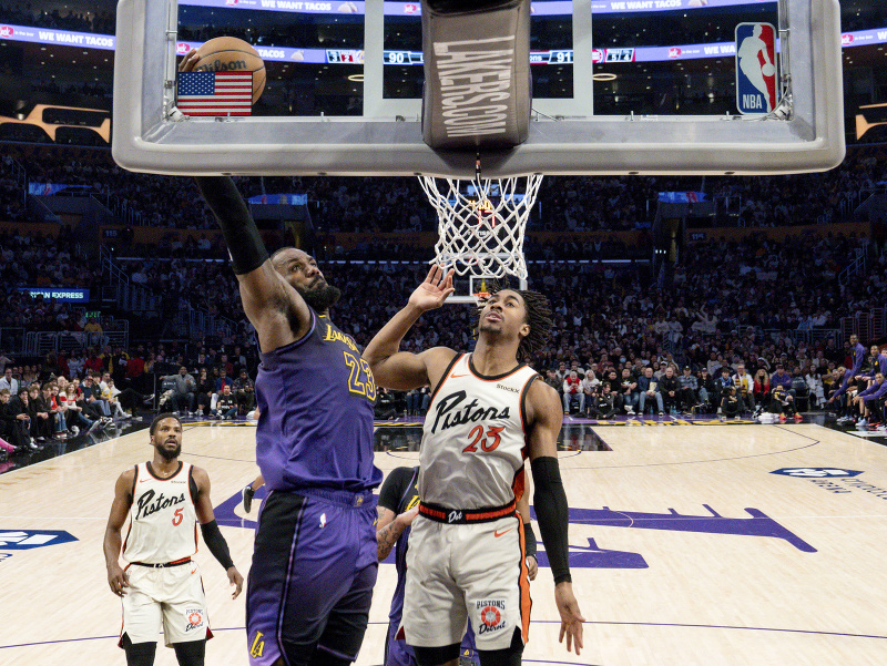 Útočník Los Angeles Lakers LeBron James (23) zakončuje a stíha ho Jaden Ivey z Detroit Pistons