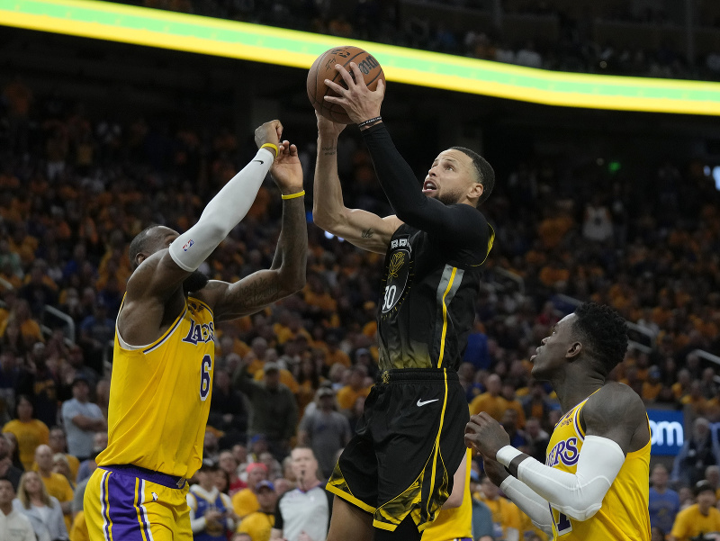 LeBron James (Los Angeles) sa snaží zastaviť Stephena Curryho (Golden State)