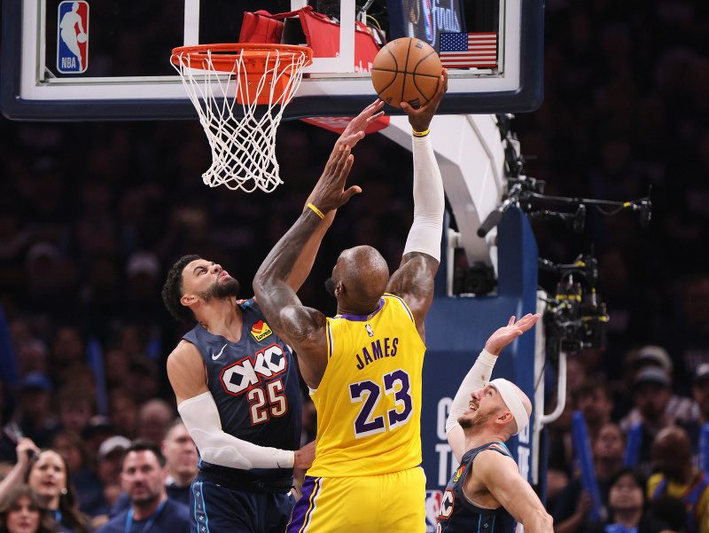 Zakončujúci LeBron James (23) a brániaci Ajay Mitchell (25) a Alex Caruso