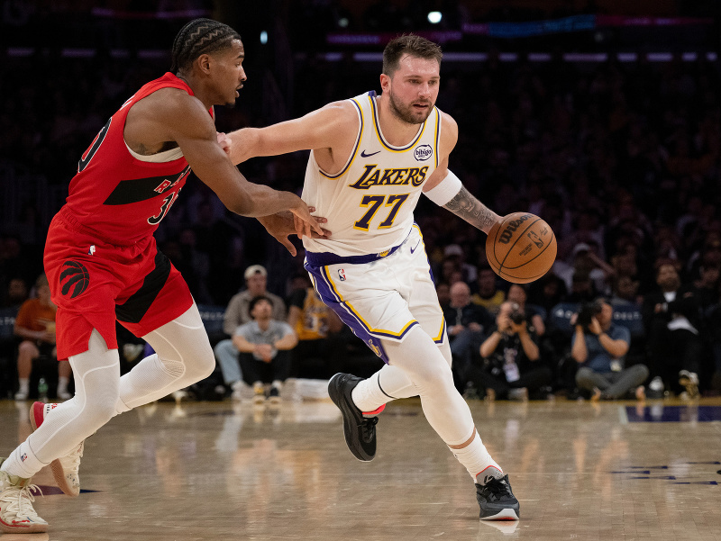 Luka Dončić s loptou, vedľa neho Ochai Agbaji z Toronta Raptors
