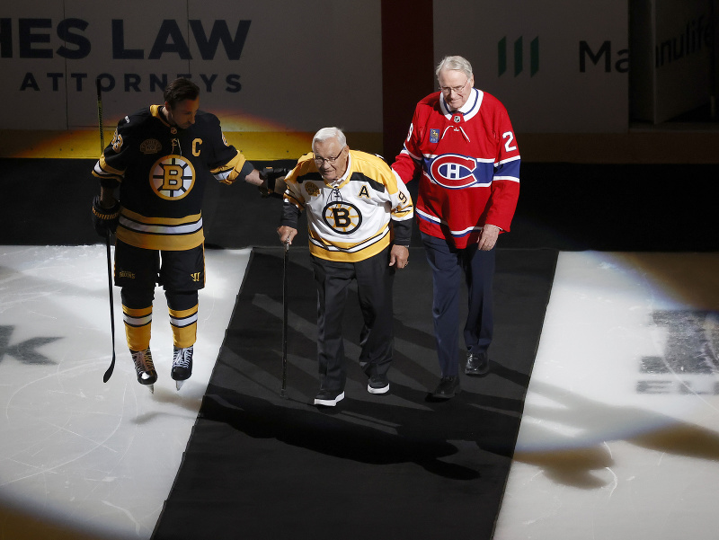 Legenda Bostonu Johnny Bucyk prichádza na ľad za sprievodu súčasného kapitána Brada Marchanda a bývalého hokejistu Montrealu Kena Drydena