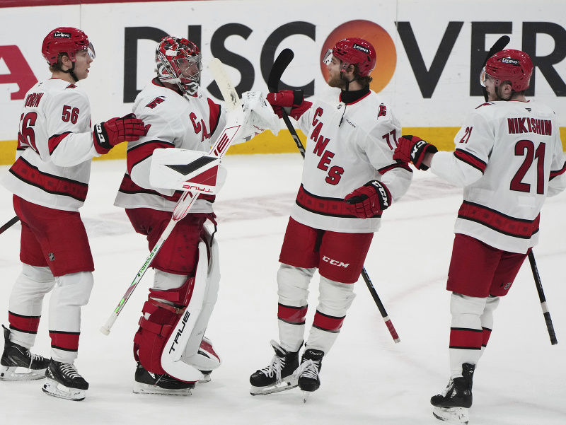 Tešiaci sa hráči Caroliny Hurricanes, zľava Scott Morrow, Frederik Andersen, Mark Jankowski a Alexander Nikišin