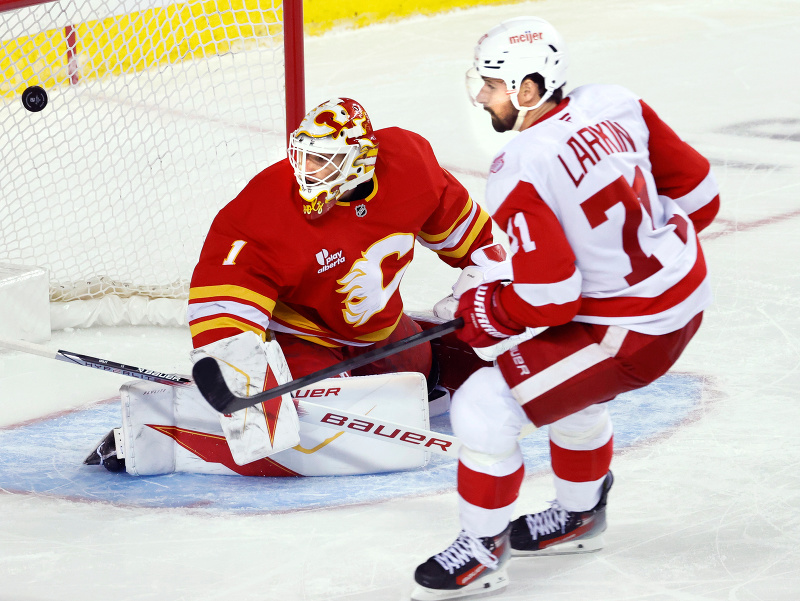 Kapitán Detroitu Dylan Larkin prekonáva brankára Calgary Devina Cooleyho