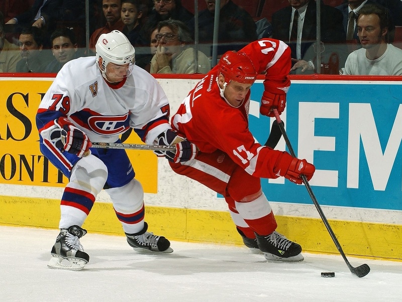 Archívna snímka z roku 2003 - Brett Hull (Detroit Red Wings) si kryje puk pred ruským obrancom Andreiom Markovom (Montreal Canadiens)