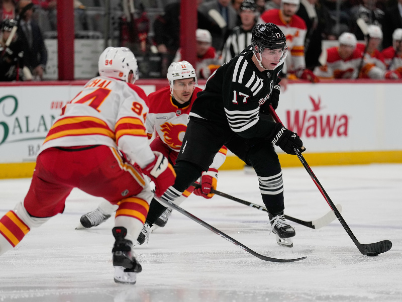 Šimon Nemec prechádza pomedzi obrancov Calgary Flames