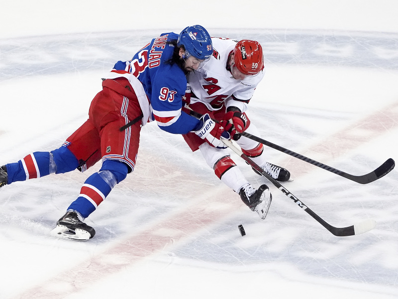 Jake Guentzel a Mika Zibanejad v súboji o puk