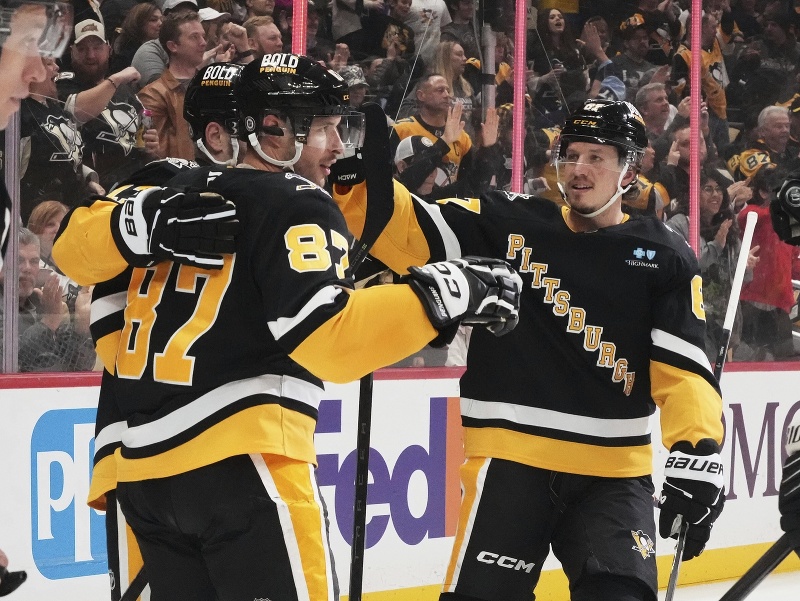 Sidney Crosby (vľavo) oslavuje gól so spoluhráčmi, vpravo Rickard Rakell