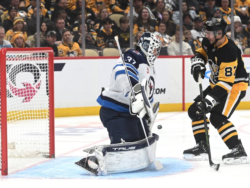 Kapitán Pittsburghu pred brankárom Winnipegu Connorom Hellebuyckom