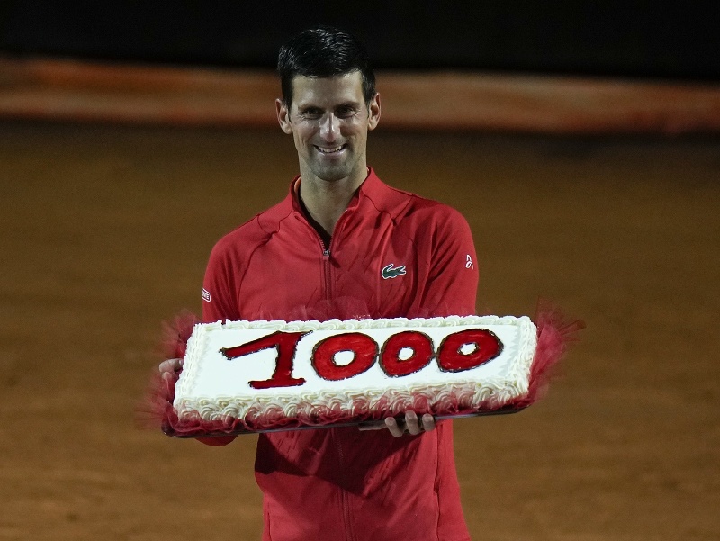 Srbský tenista Novak Djokovič drží tortu s číslicou tisíc