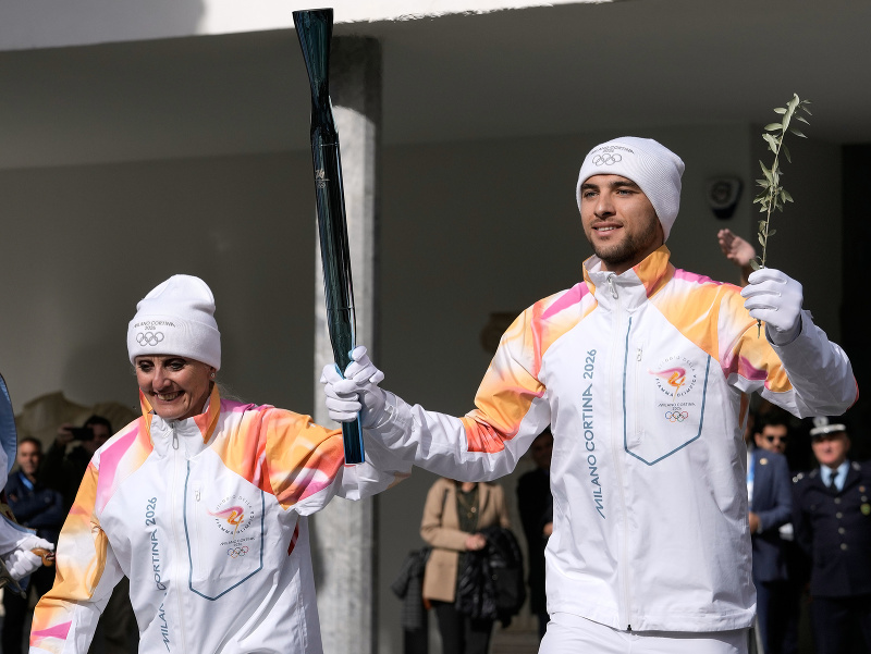 Petros Gkaidatzis a Stefanie Belmondová nesú pochodeň počas slávnostného zapálenia olympijského ohňa na budúcoročné ZOH v talianskom Miláne a Cortine d'Ampezzo v gréckej Olympii