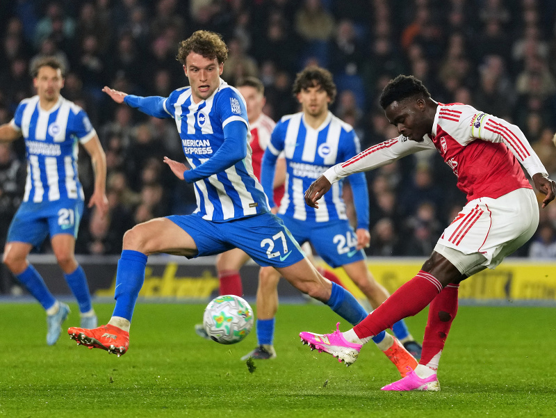 Hráč Arsenalu Bukayo Saka (vpravo) strieľa cez Matsa Wieffera z Brightonu 