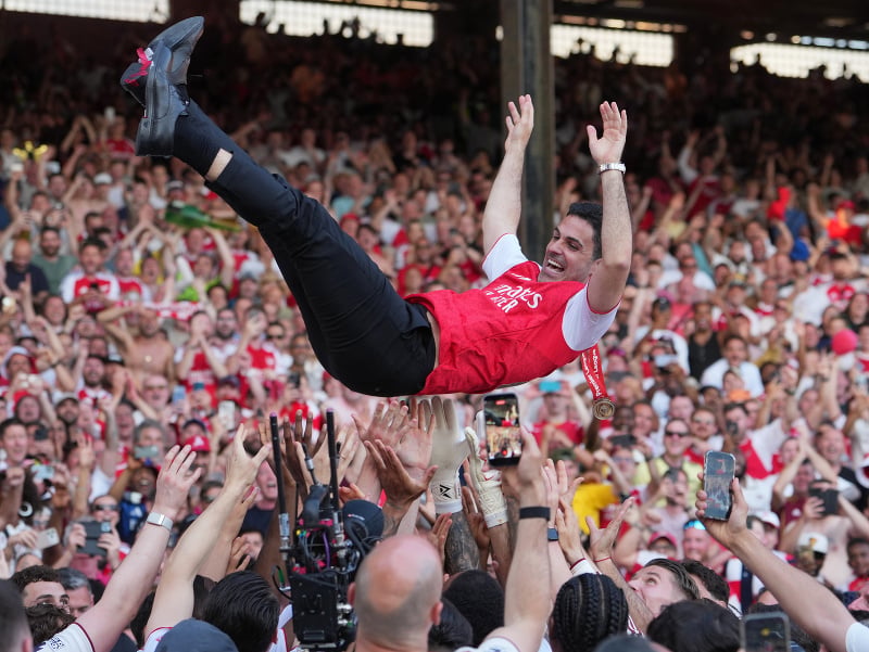 Futbalisti Arsenalu vyhadzujú do vzduchu trénera Arsenalu Mikela počas osláv majstrovského titulu