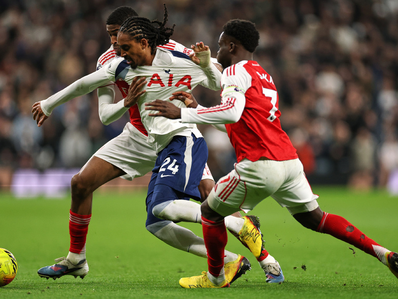 Hráči Arsenalu Cristhian Mosquera (vzadu) Bukayo Saka bojujú o loptu proti Djedovi Spencemu z Tottenhamu