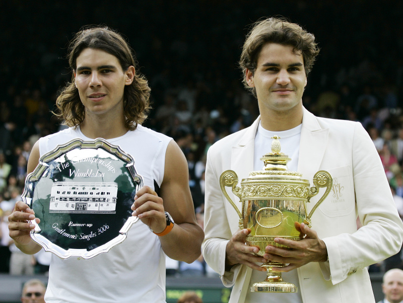 Na archívnej snímke z 9. júla 2006 sprava švajčiarsky tenista a víťaz turnaja Roger Federer a Španiel Rafael Nadal pózujú s trofejami po finále mužskej dvojhry grandslamového turnaja Wimbledon v Londýne