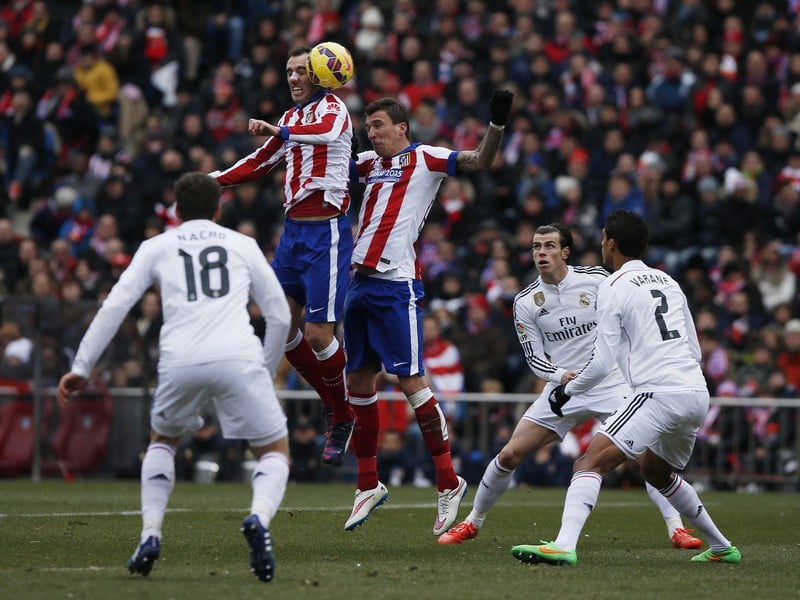 Diego Godín a Mario Mandžukič v súboji s hráčmi Realu