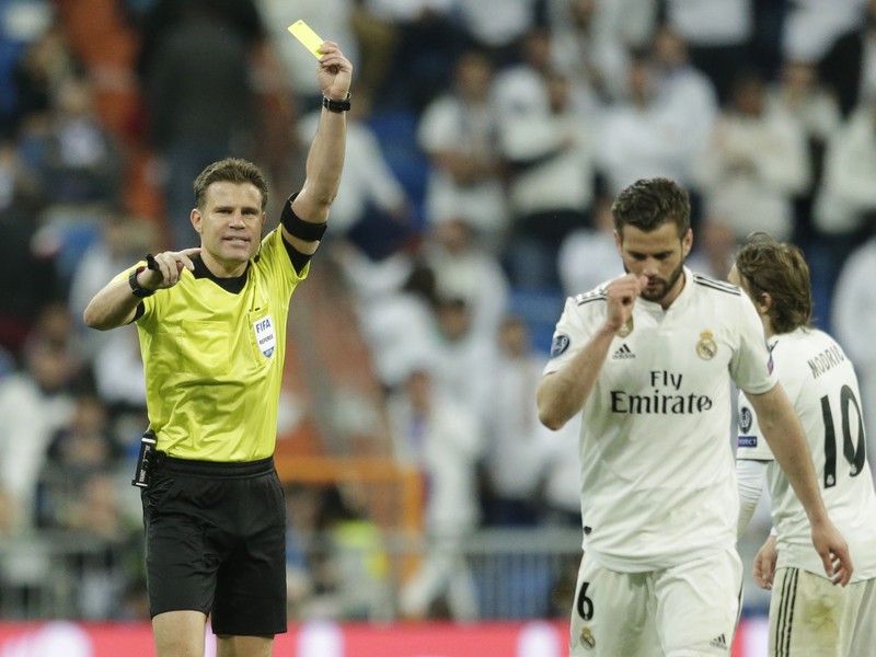 Rozhodca Felix Brych ukazuje žltú kartu obrancovi Realu Madrid Nachovi Fernandezovi