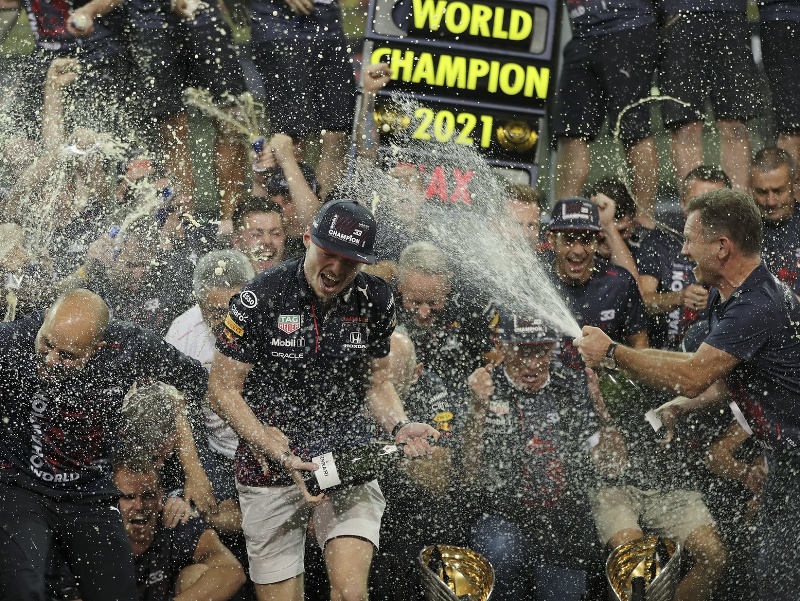 Holandský pilot formuly 1 Holanďan Max Verstappen (vľavo) z tímu Red Bull oslavuje víťazstvo v rozhodujúcich pretekoch sezóny 2021