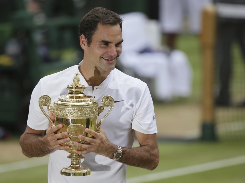 Švajčiar Roger Federer pózuje fotografom s trofejou po víťazstve vo finálovom zápase proti Chorvátovi Marinovi Čiličovi v mužskej dvojhre na grandslamovom turnaji vo Wimbledone 