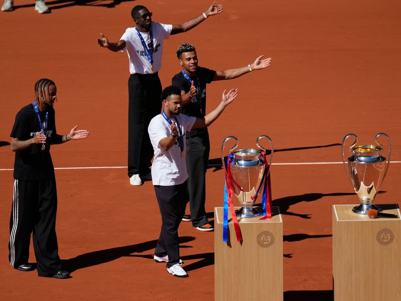 Futbalisti Paríža St. Germain Bradley Barcola (vľavo), Warren Zaire-Emery (uprostred), Desire Doue (vpravo) a Ousmane Dembele prezentujú trofeje po obhajobe titulu v Lige majstrov