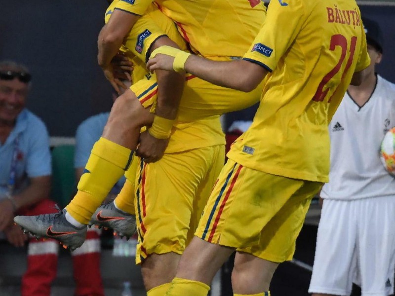 Na snímke vľavo hráč Rumunska Adrian Petre oslavuje gól