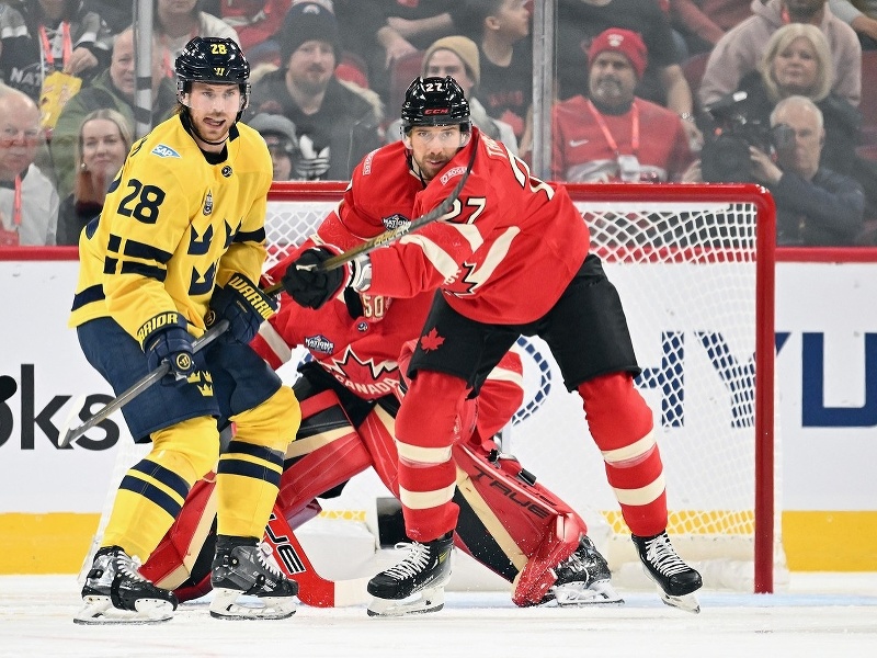 Elias Lindholm a Shea Theodore (v červenom drese) počas zápasu