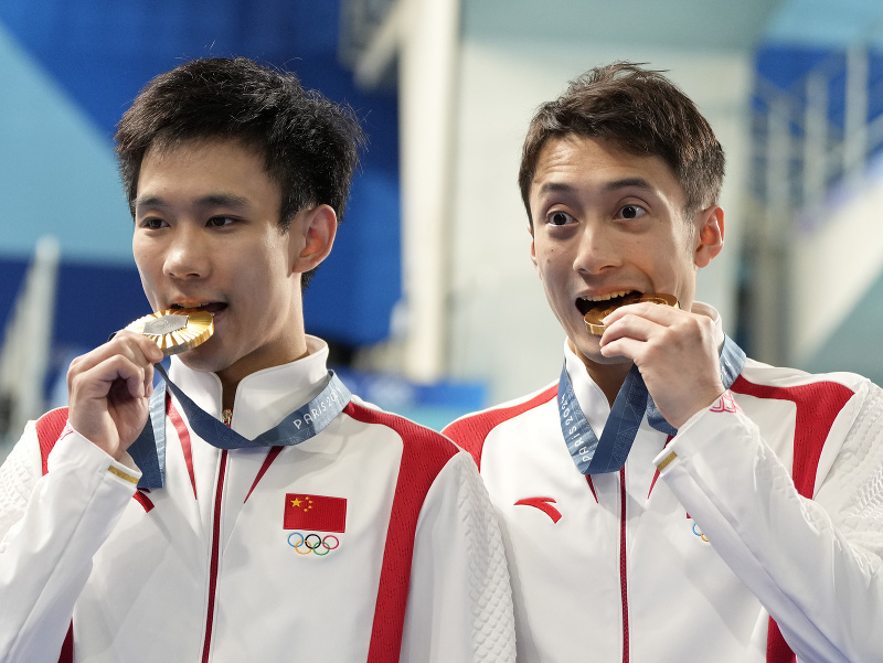 Čínski skokani do vody Lien Ťün-ťie a Jang Chao pózujú so zlatými medailami v synchronizovaných skokoch z 10 m veže na XXXIII. letných olympijských hrách 2024 v Paríži 