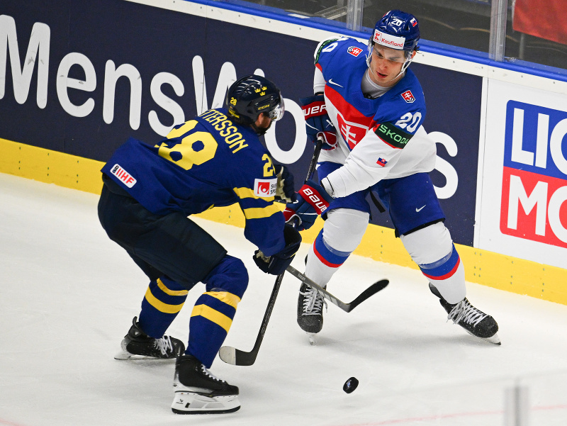 Juraj Slafkovský v súboji o puk so švédskym hráčom Marcusom Petterssonom