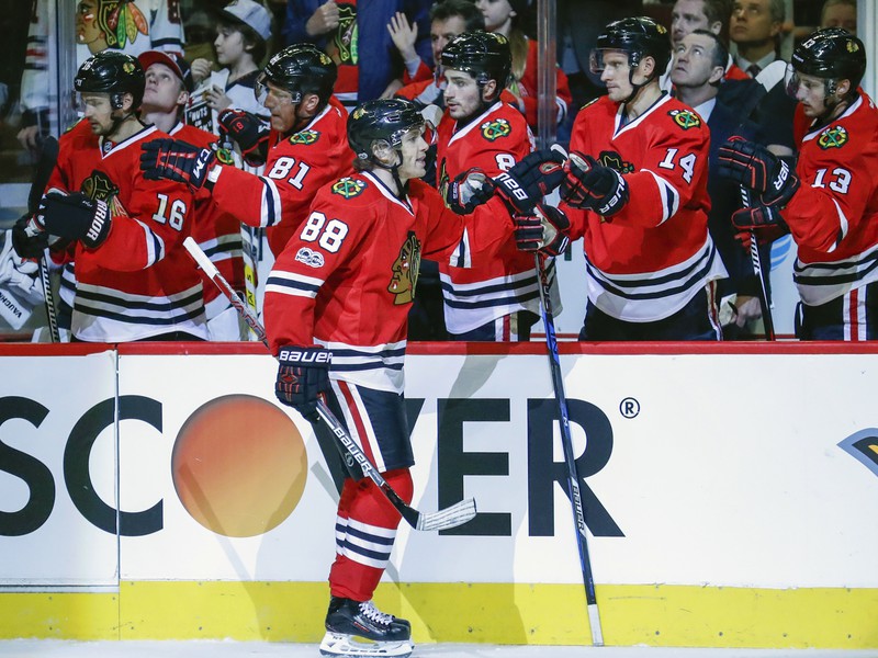 Patrick Kane sa teší z gólu so spoluhráčmi na lavičke.