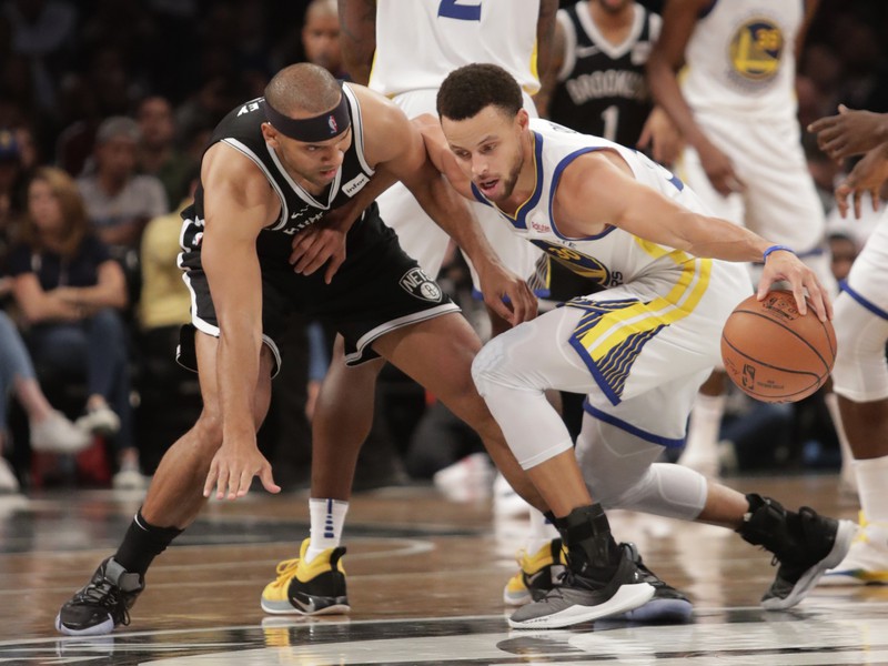 Basketbalista Golden State Wariors Stephen Curry (vpravo) a hráč Brooklynu Nets Jared Dudley bojujú o loptu