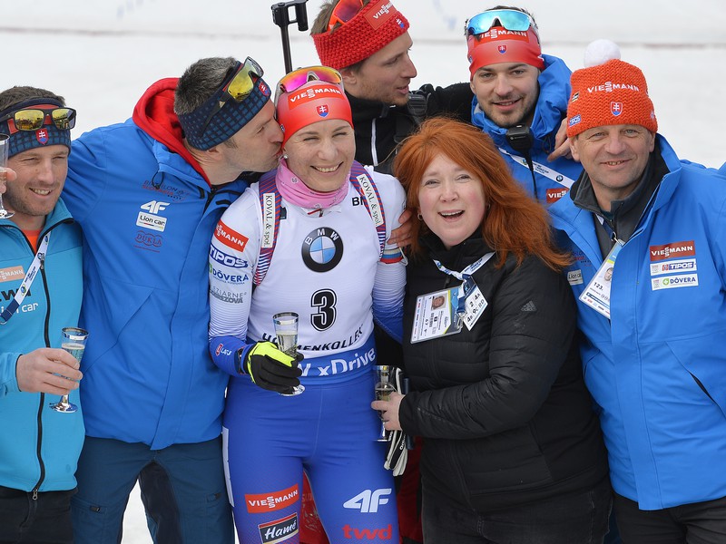 Anastasia Kuzminová, naľavo ju bozkáva manžel Daniel s jej tímom a pretekármi počas rozlúčky s kariérou v cieli pretekov s hromadným štartom